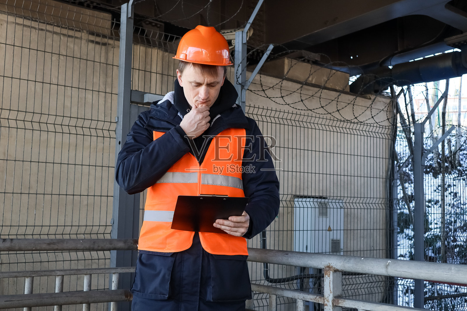 身着工作服的工人在认真地审阅文件照片摄影图片