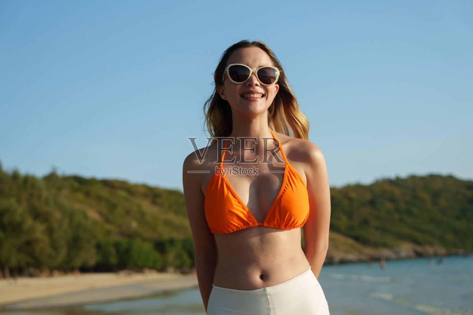 这张照片展示了一位快乐的女性在热带岛屿海滩上享受浪漫假期。照片摄影图片