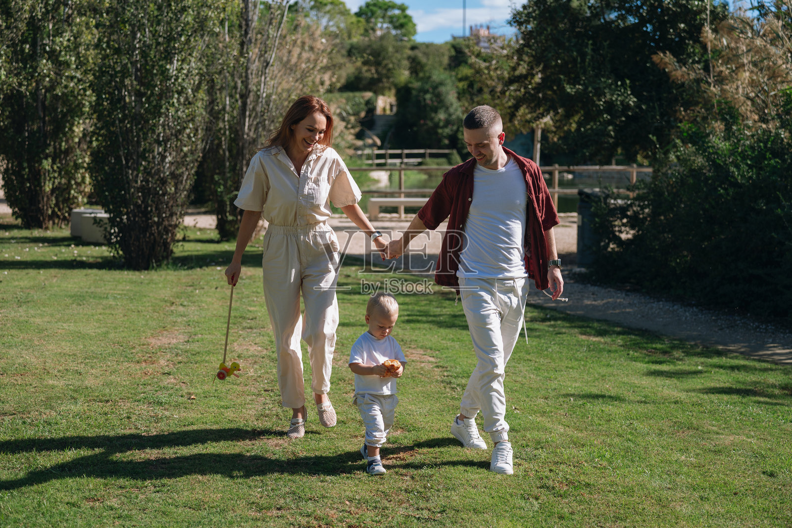 快乐的一家人手牵手在公园里散步照片摄影图片