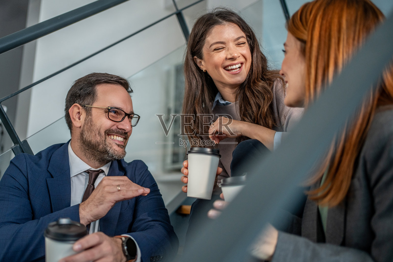 商务同事在办公室楼梯上享受咖啡休息时间照片摄影图片