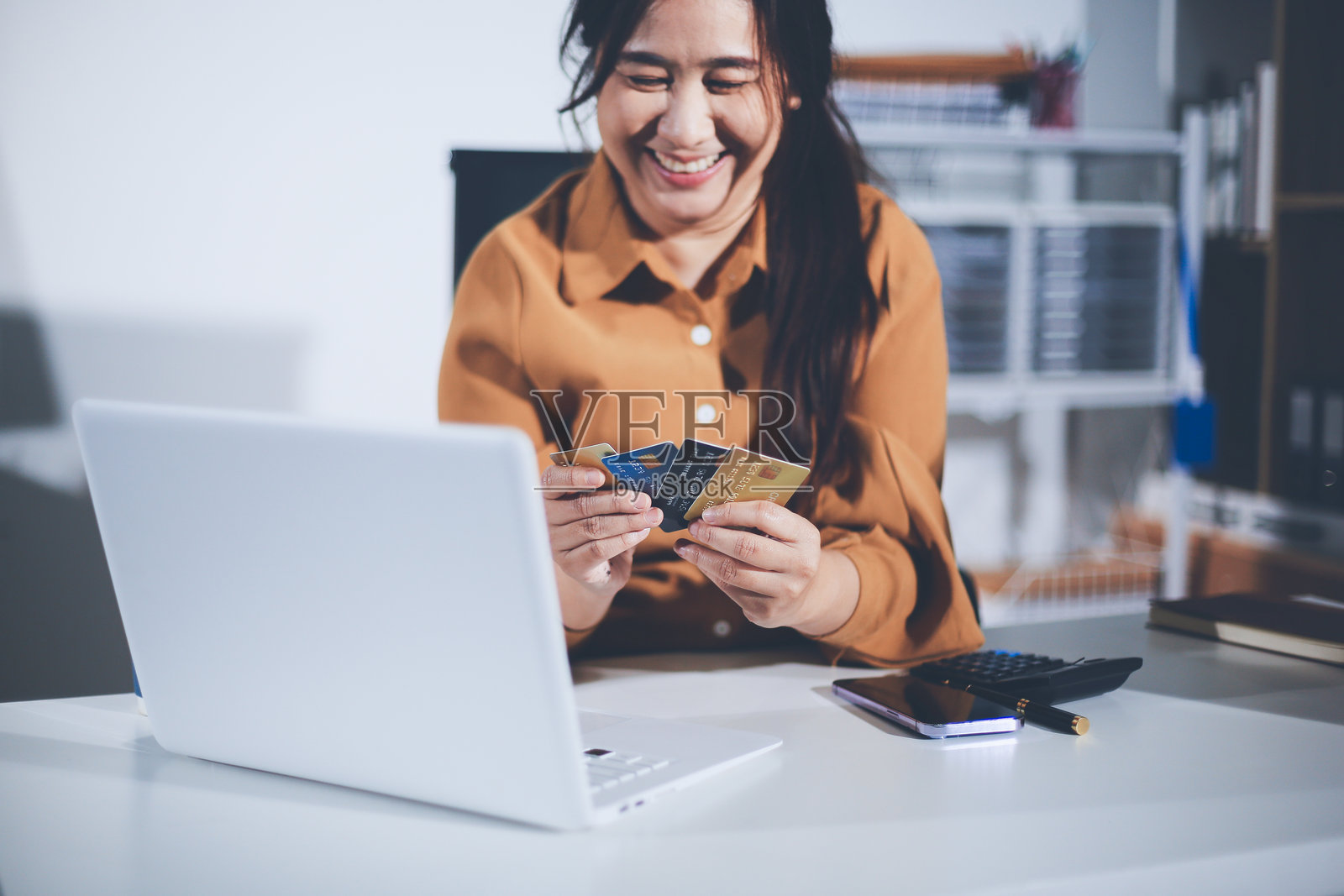 在线支付，女人用信用卡和智能手机进行在线购物照片摄影图片