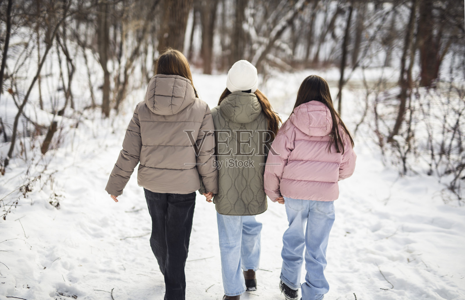 寒冷冬日，三位朋友在户外。照片摄影图片
