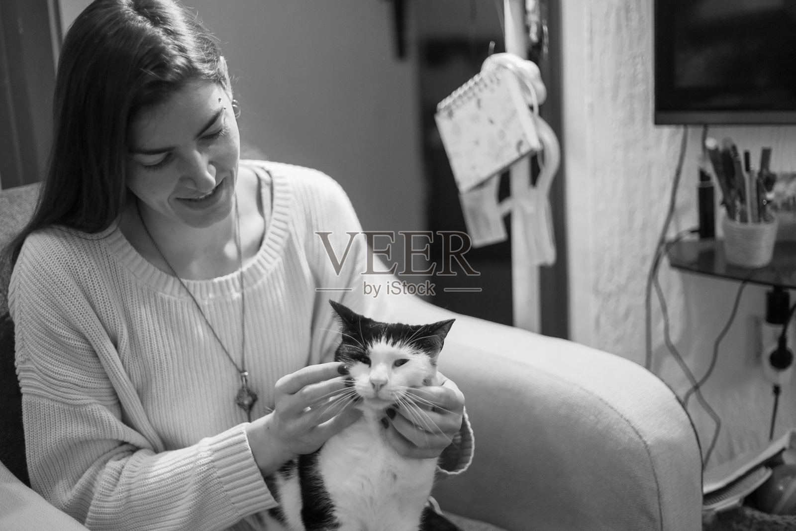女子在室内轻轻抚摸猫，黑白照片照片摄影图片