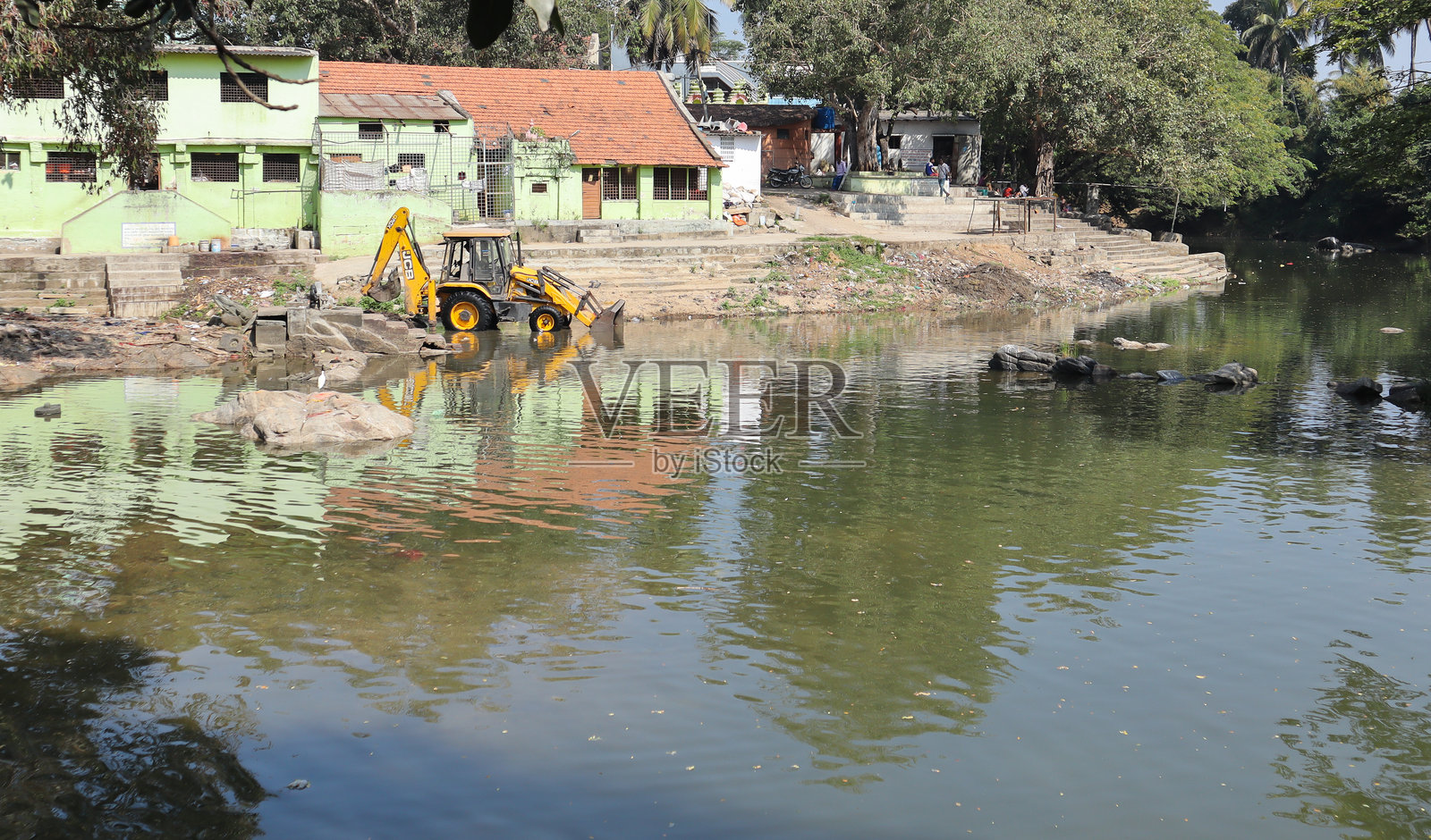 重型JCB挖掘机在印度卡纳塔克邦部署，用于清理河流中的垃圾、塑料、淤泥、杂物和废物，以保护环境。照片摄影图片