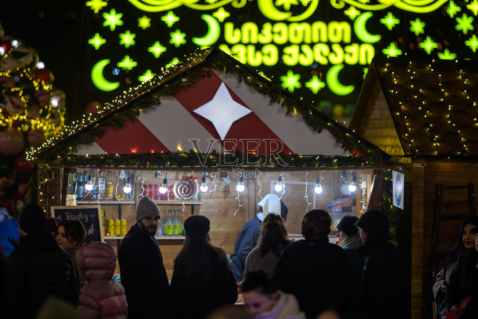 格鲁吉亚首都第比利斯圣诞集市上，节日集市摊位在装饰灯的映衬下熠熠生辉。照片摄影图片