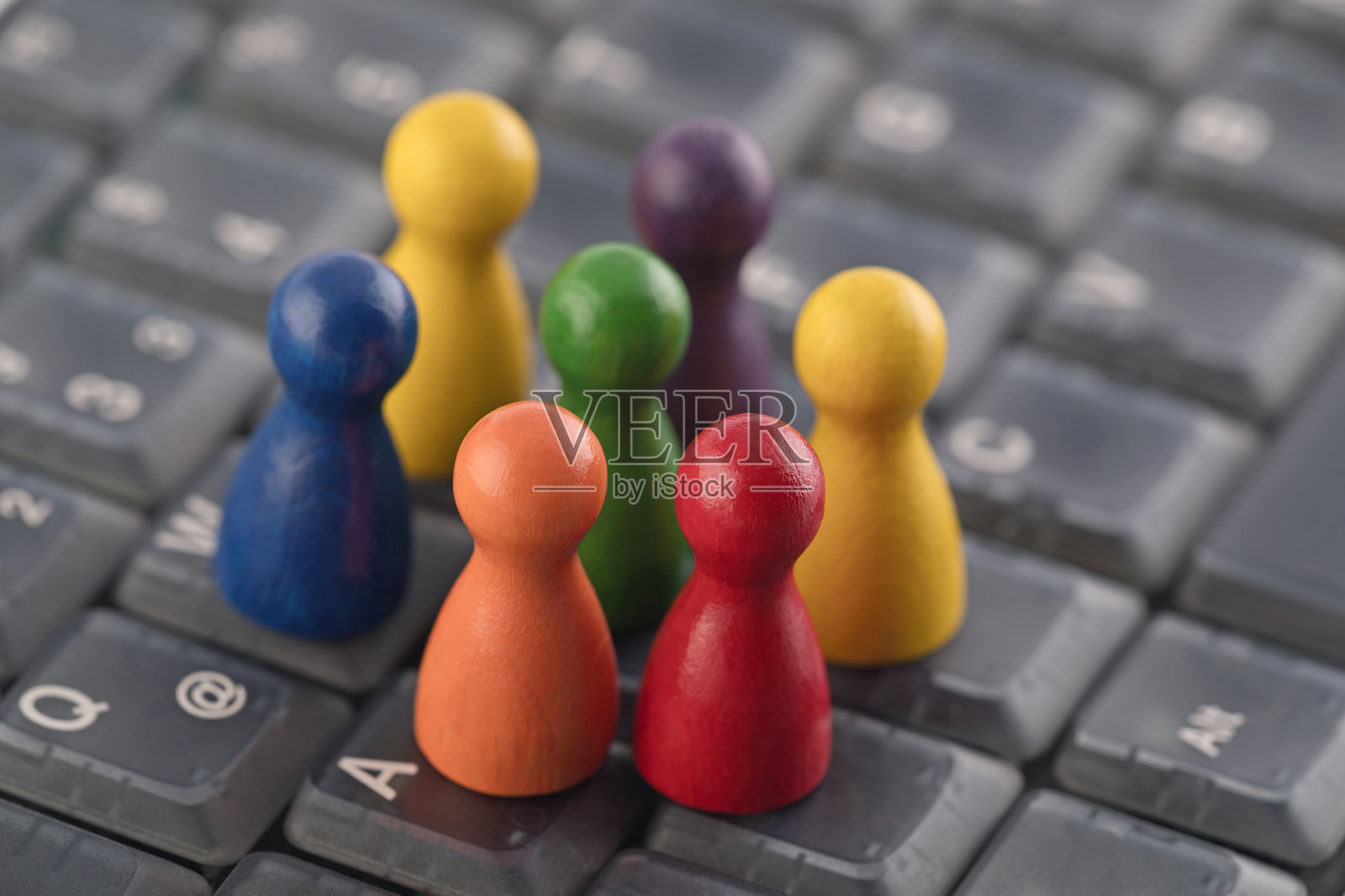 彩色棋子人偶在电脑键盘上照片摄影图片