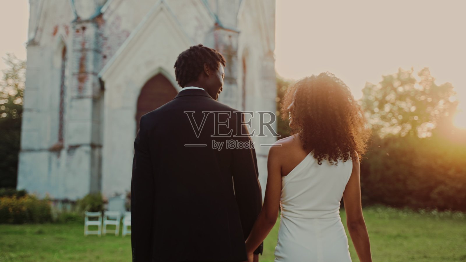 新人牵手走向落日照片摄影图片