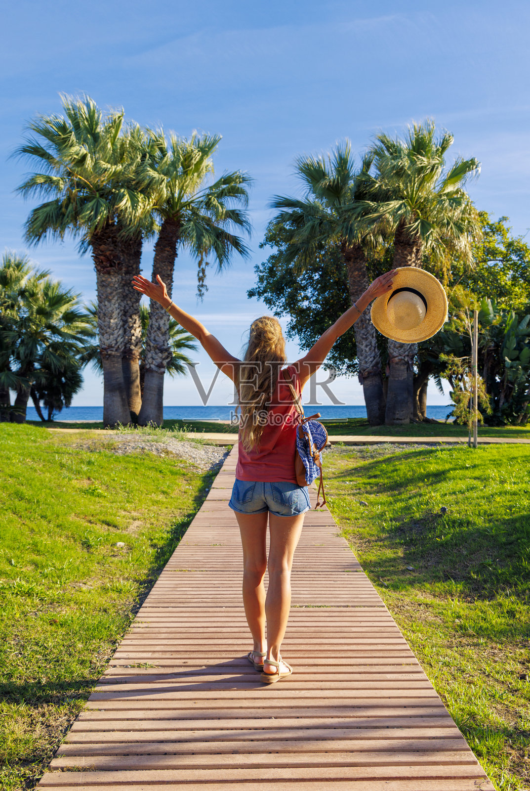 一位快乐的女游客在热带风光中张开双臂走向大海照片摄影图片