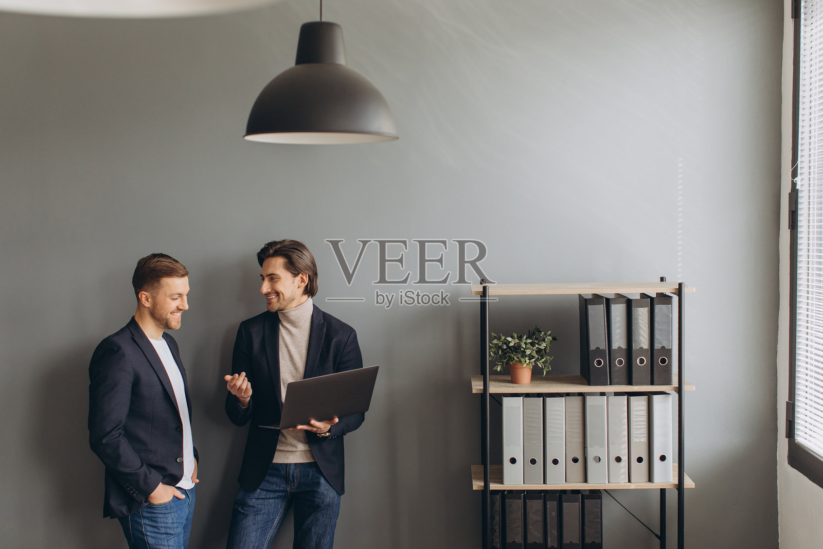 专业商务人士在现代办公室环境中协作项目，讨论想法，使用笔记本电脑照片摄影图片