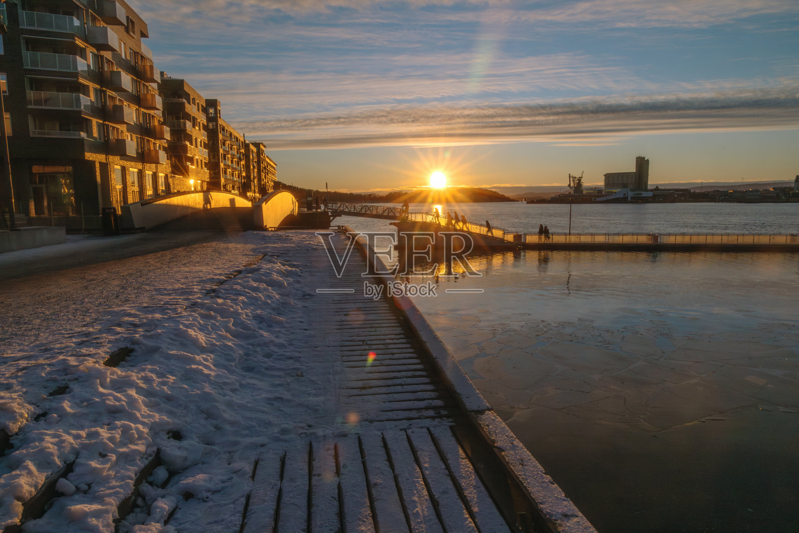 挪威奥斯陆，冬季日落时分，索伦加海滨和冰封港口，现代公寓建筑照片摄影图片