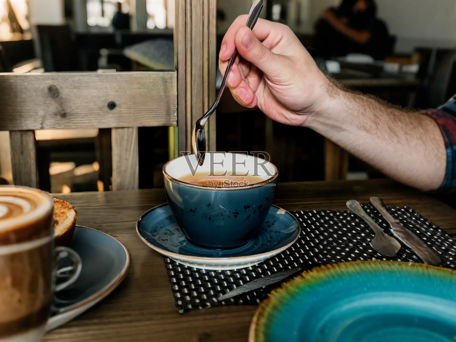 咖啡杯，咖啡店早餐，晨间咖啡的美学，一杯茶的美照，搅动茶水，手中拿着勺子，男人坐在咖啡馆，在咖啡馆喝茶，咖啡馆里的美照，美式咖啡美照照片摄影图片