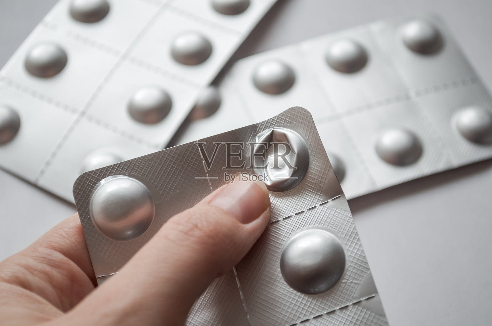 手拿着一个用过的透明泡罩包装照片摄影图片