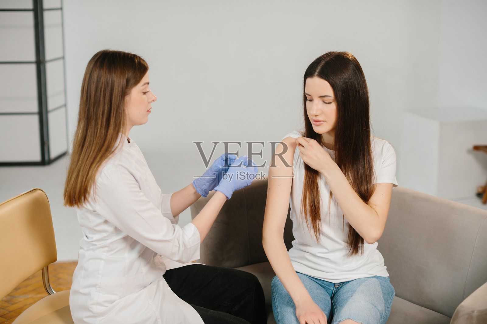 医务人员为年轻女性接种疫苗以预防疾病照片摄影图片