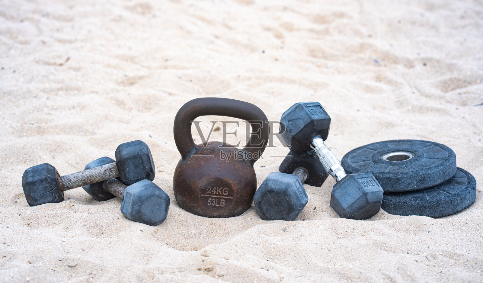 运动壶铃训练。沙滩上的运动哑铃。活力四射的户外健身。运动举重锻炼。杠铃举重。运动健身动力。照片摄影图片