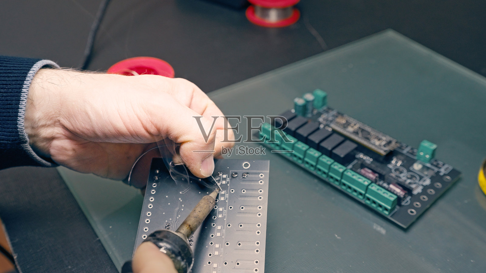 工程师在印刷电路板上焊接元件的特写照片摄影图片