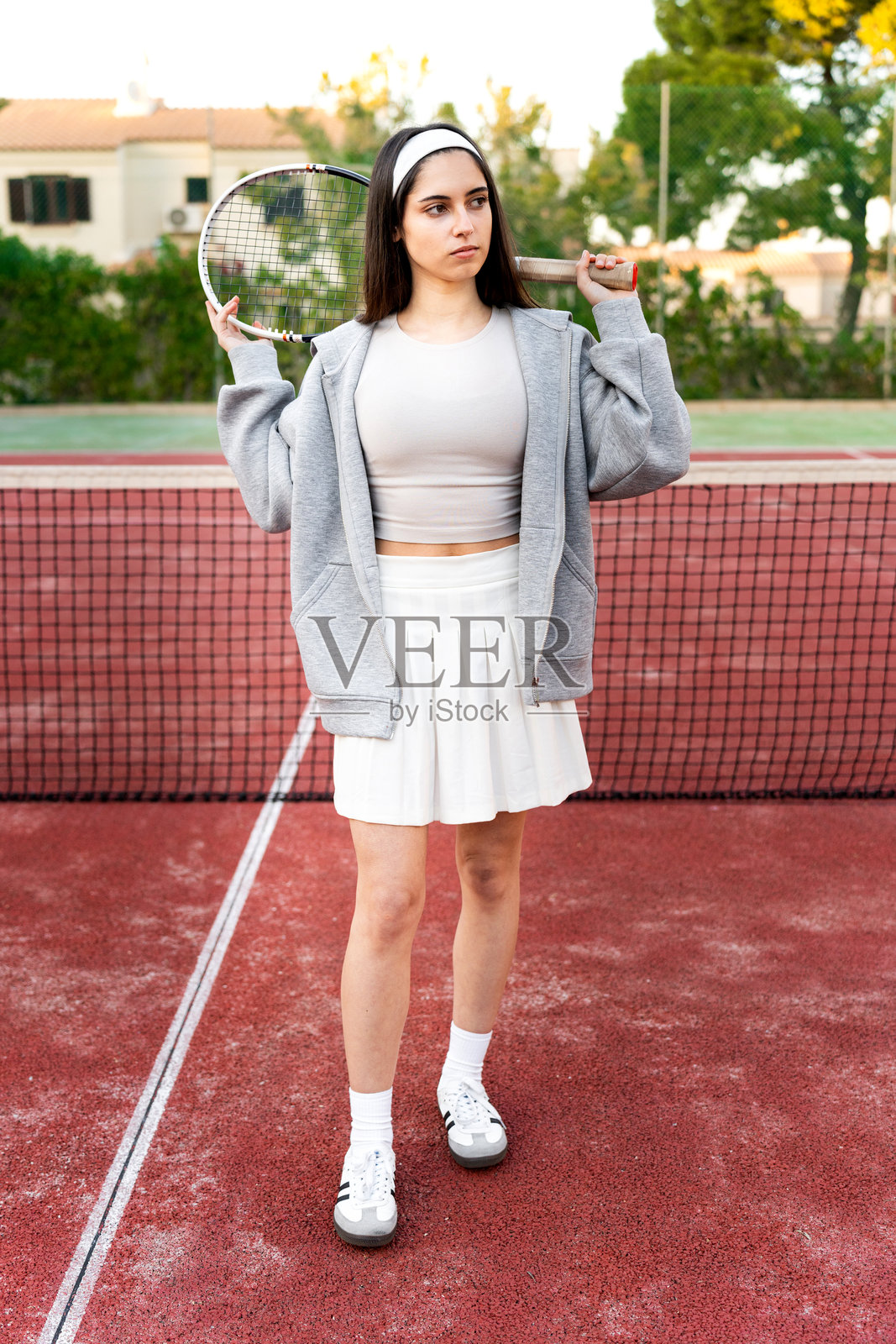 年轻女子在球场上握着网球拍照片摄影图片