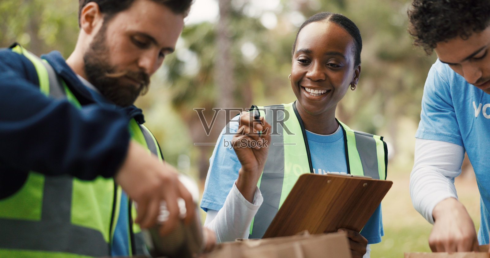 剪贴板、户外或志愿服务人员与纸袋、社区服务或慈善募捐包装。团队合作、非营利组织或女性与捐赠清单、粮食安全危机、检查或公园照片摄影图片