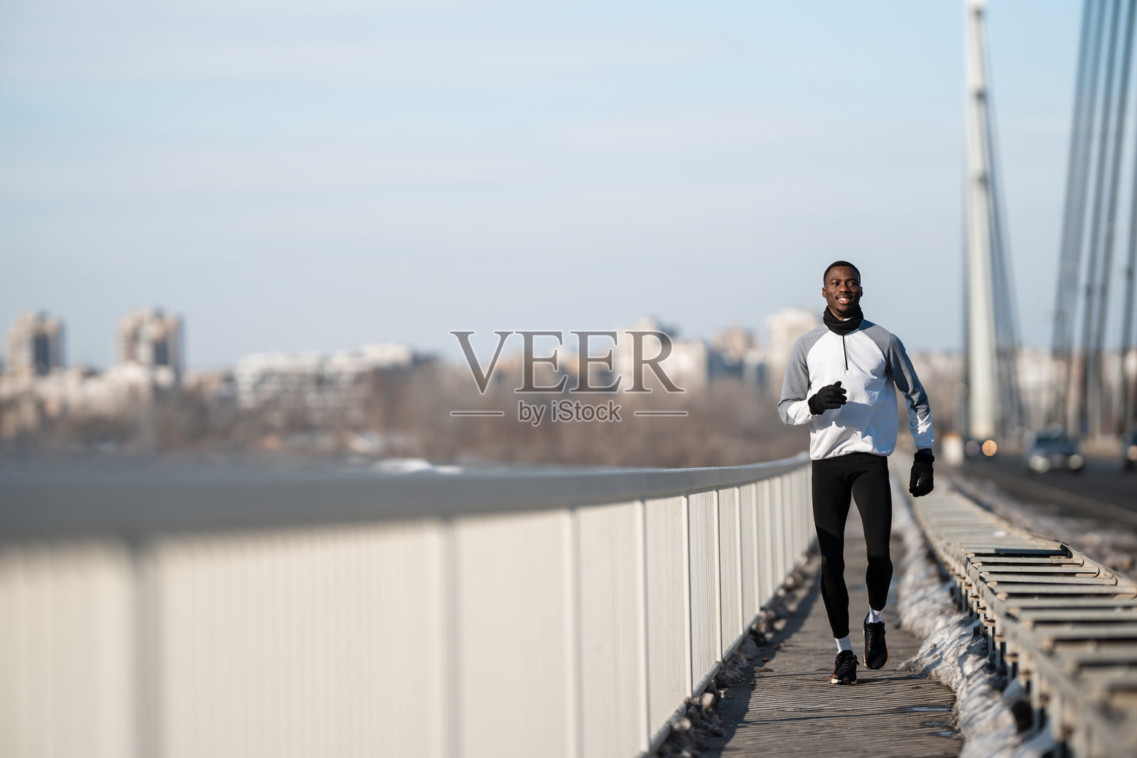冬季在桥上慢跑的非洲裔美国男子照片摄影图片