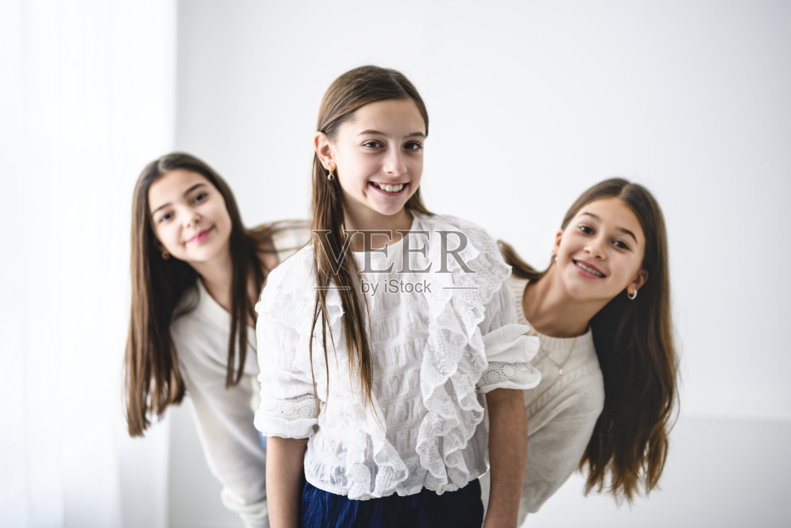 三位少女好友在纯白影棚背景前照片摄影图片