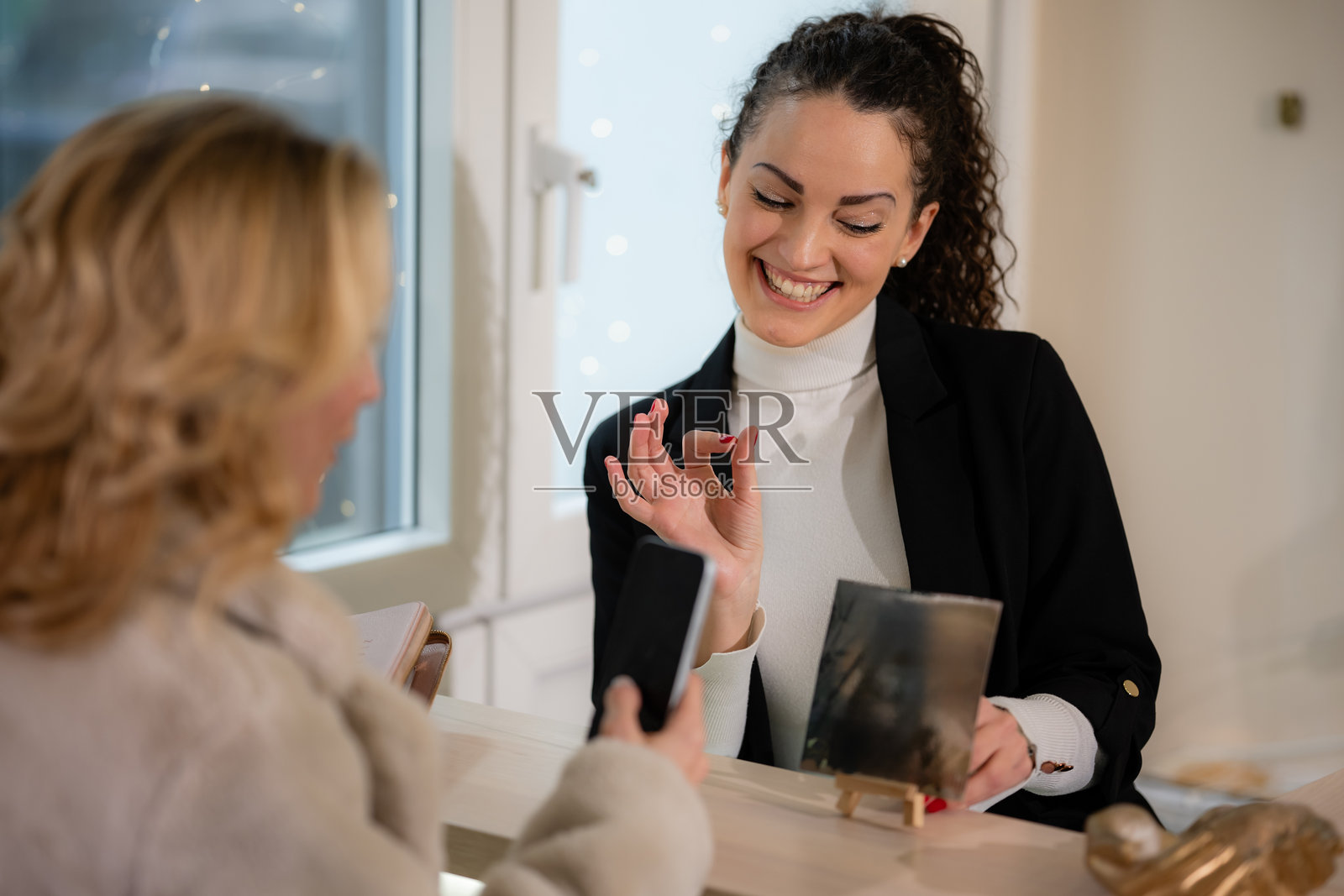 女子用智能手机扫描二维码支付服务费用照片摄影图片