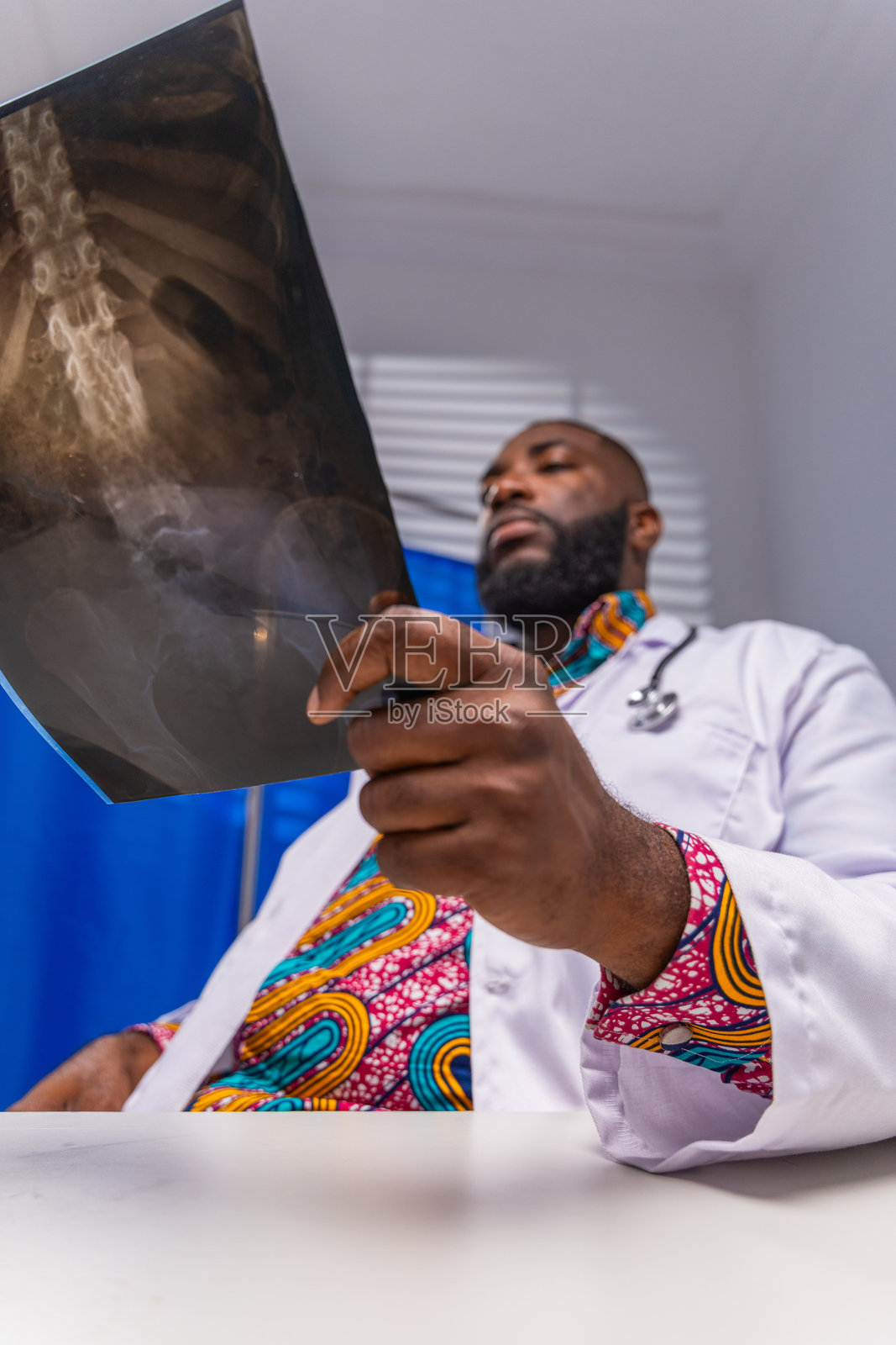 非洲男性医生在医院检查骨盆X光片照片摄影图片