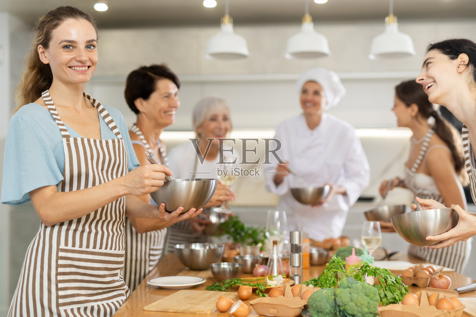 年轻女子在大师班学习烹饪照片摄影图片