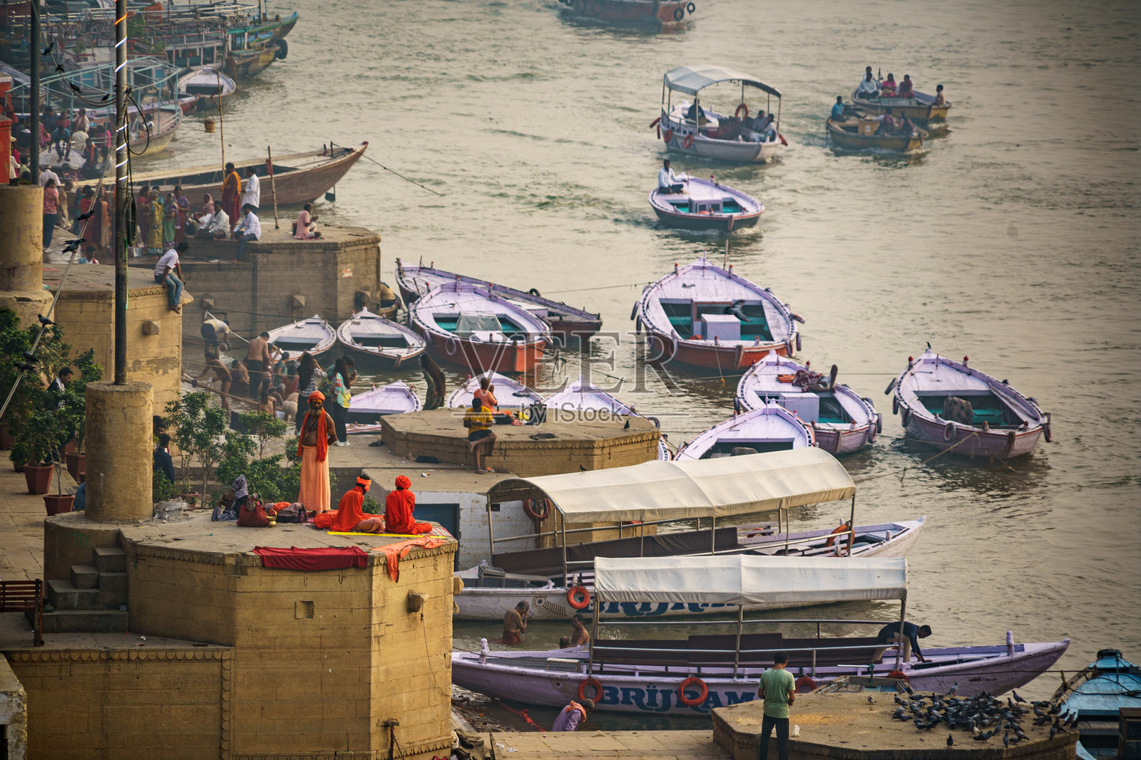 印度。北方邦。瓦拉纳西（贝拿勒斯）。黎明时分，朝圣者和船夫在恒河岸边熙熙攘攘。照片摄影图片