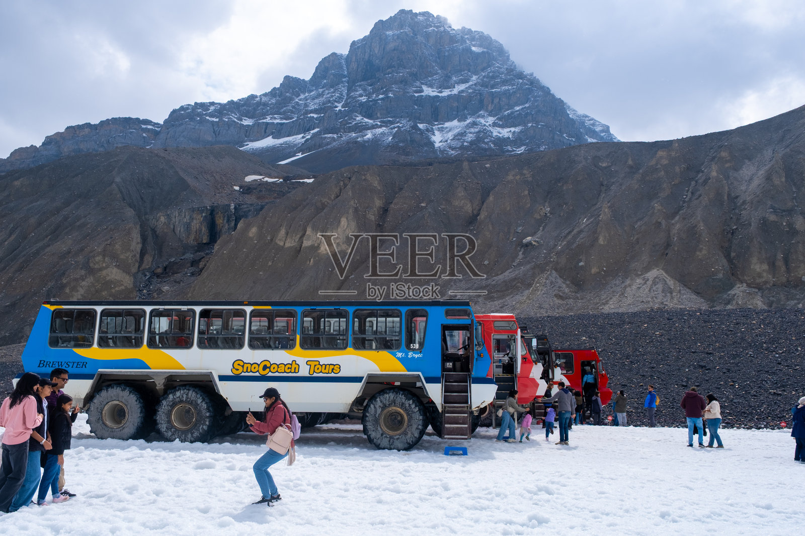 游客在山区的一天中，乘坐大型车辆在加拿大班夫附近的雪地区域进行旅游观光照片摄影图片