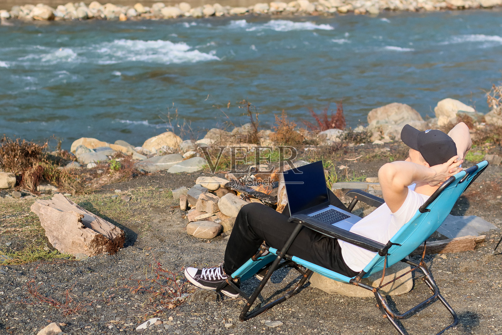 滨水躺椅上的放松姿势，旁边放着笔记本电脑照片摄影图片
