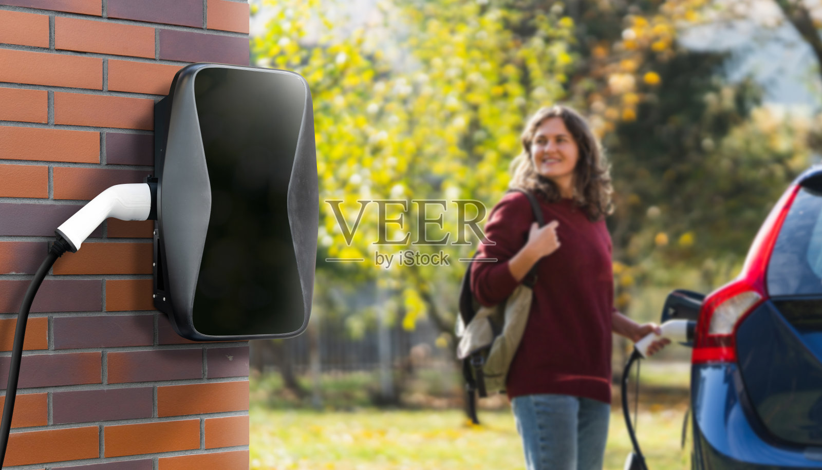 背着背包的女性旅行者站在充电电动车旁边照片摄影图片