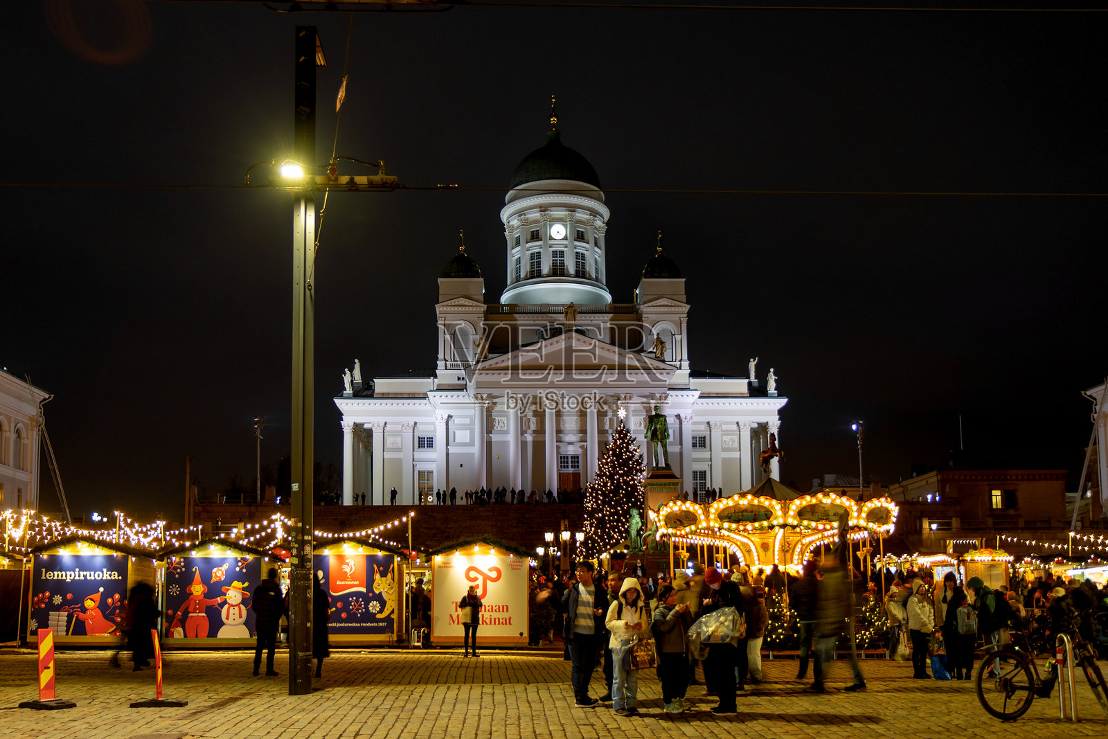 赫尔辛基圣诞市场，图奥马集市，参议院广场，背景是赫尔辛基大教堂。节日集市摊位、节日灯饰、芬兰美食、手工艺品、复古旋转木马，游客和参观者。照片摄影图片