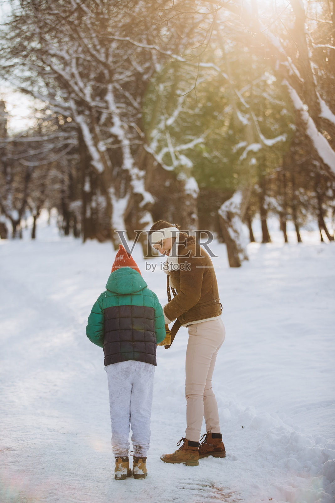 阳光明媚的冬日公园里，母子俩亲密互动照片摄影图片