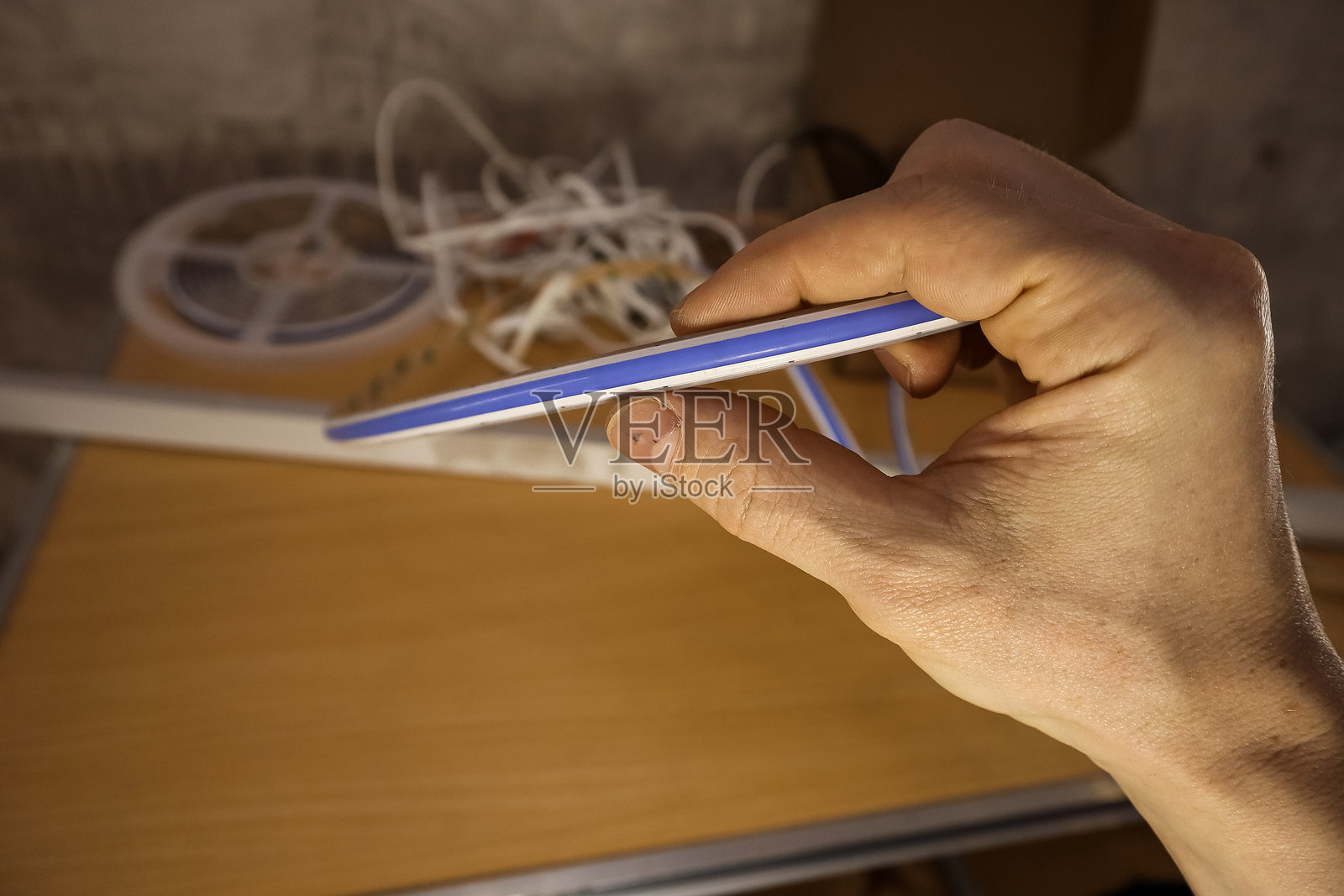 手握蓝色LED灯带片段照片摄影图片