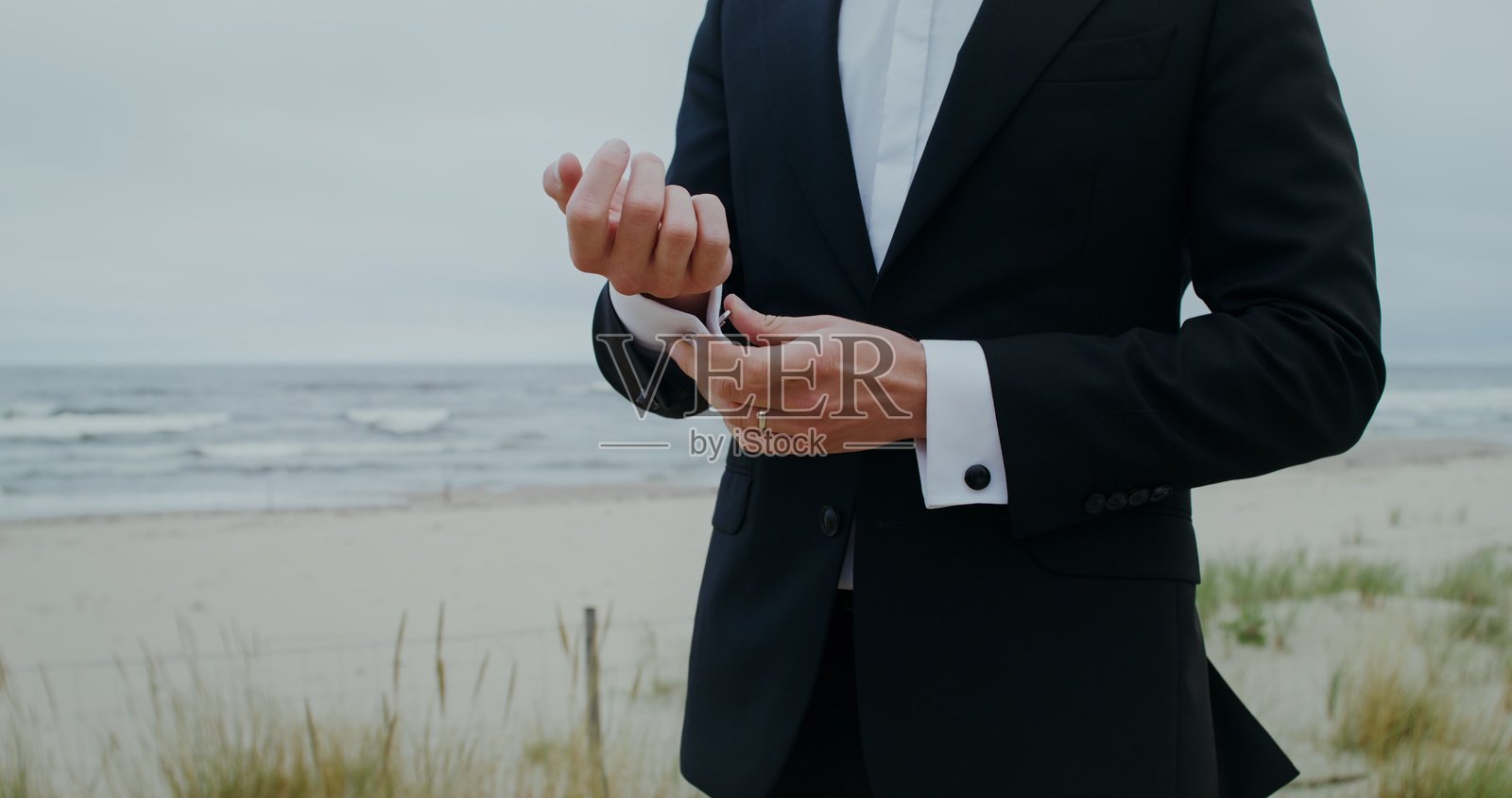 新郎正在为衬衫系袖扣 - 婚礼照片摄影图片