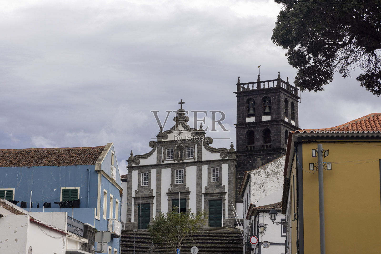 一座带有钟楼的教堂坐落在城镇的背景中照片摄影图片