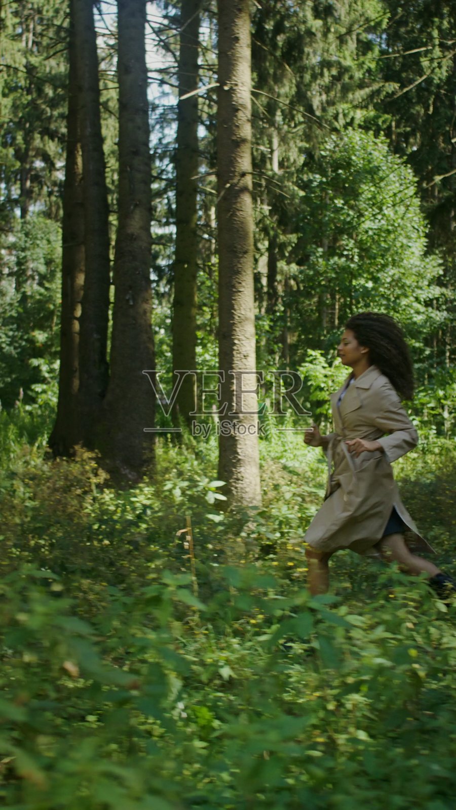 一位穿着外套的年轻女子跑过。照片摄影图片