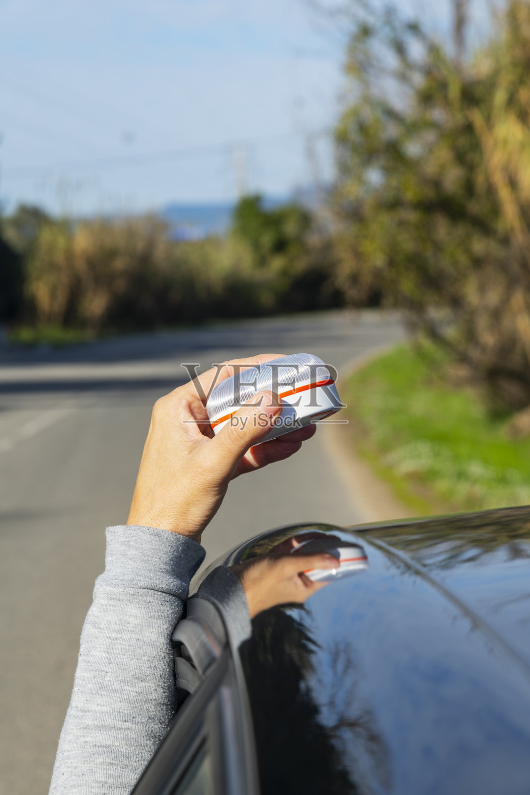 男子将V16警示灯举过车顶照片摄影图片