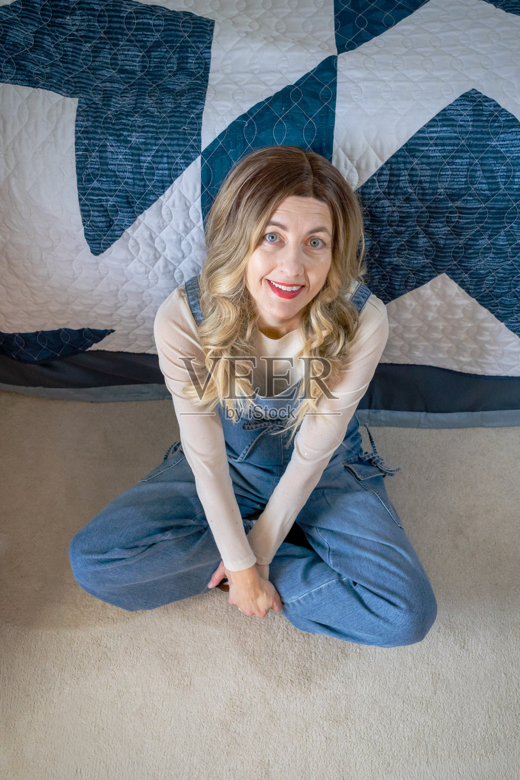 中年女子坐在卧室地板上，抬头向上看照片摄影图片