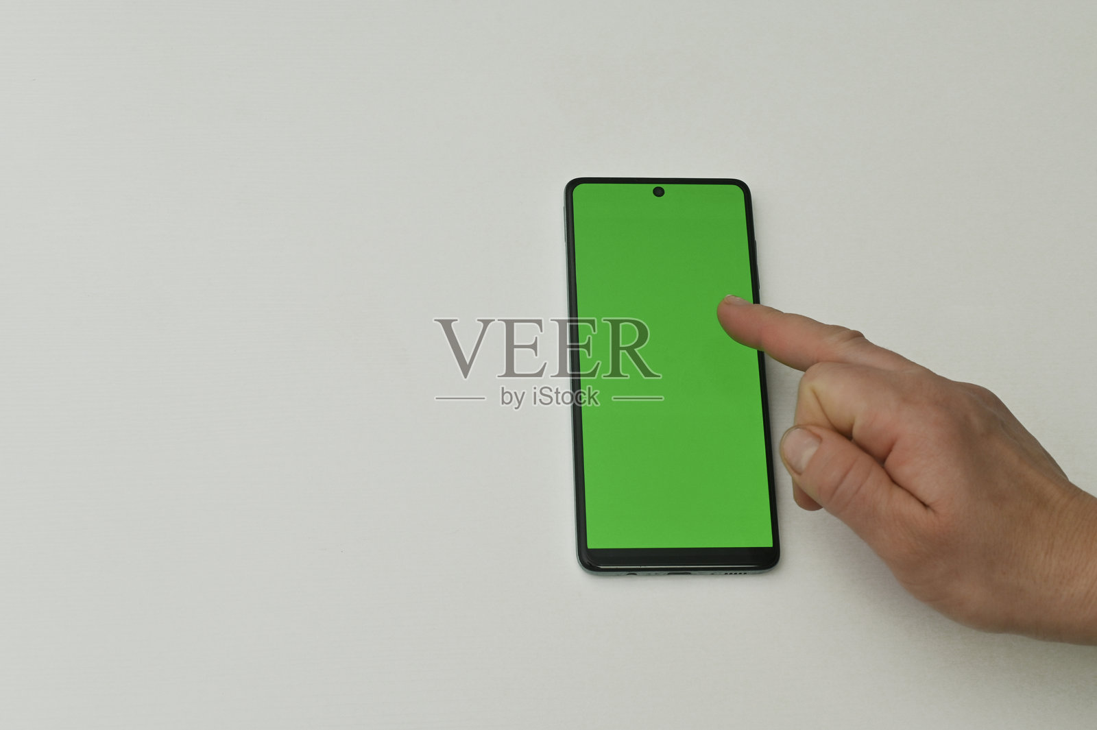 一个人用手指点击带有绿色背景的智能手机屏幕照片摄影图片