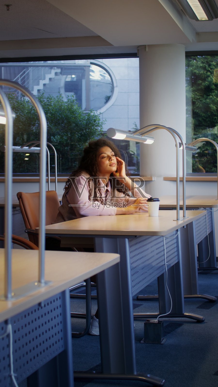 一位年轻女子将头靠在上面。照片摄影图片