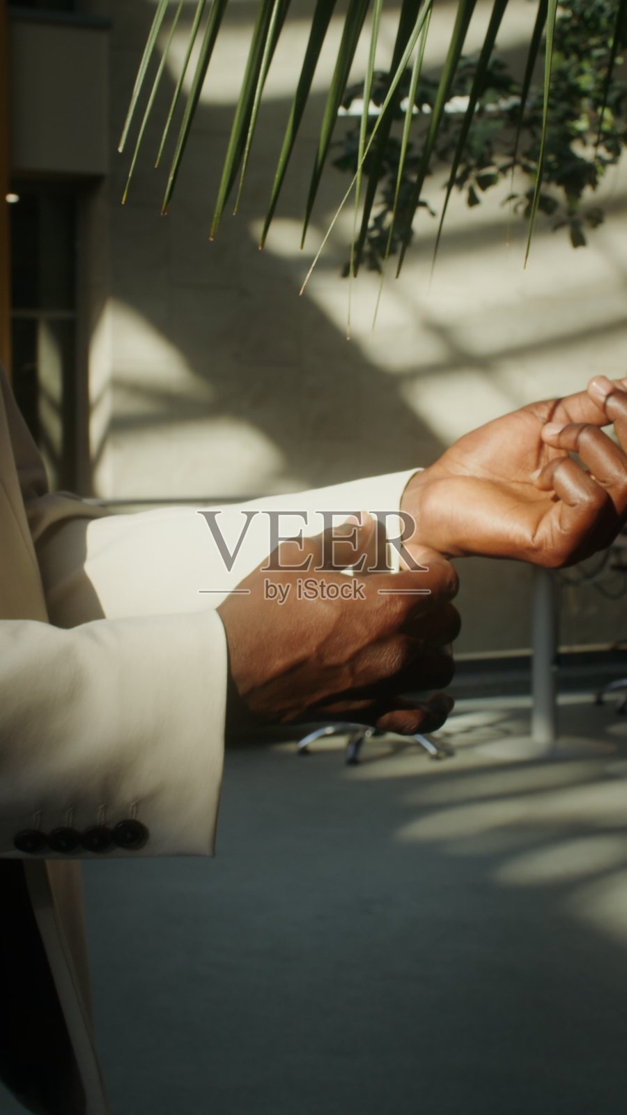 一名男子正在整理他的夹克袖子。照片摄影图片