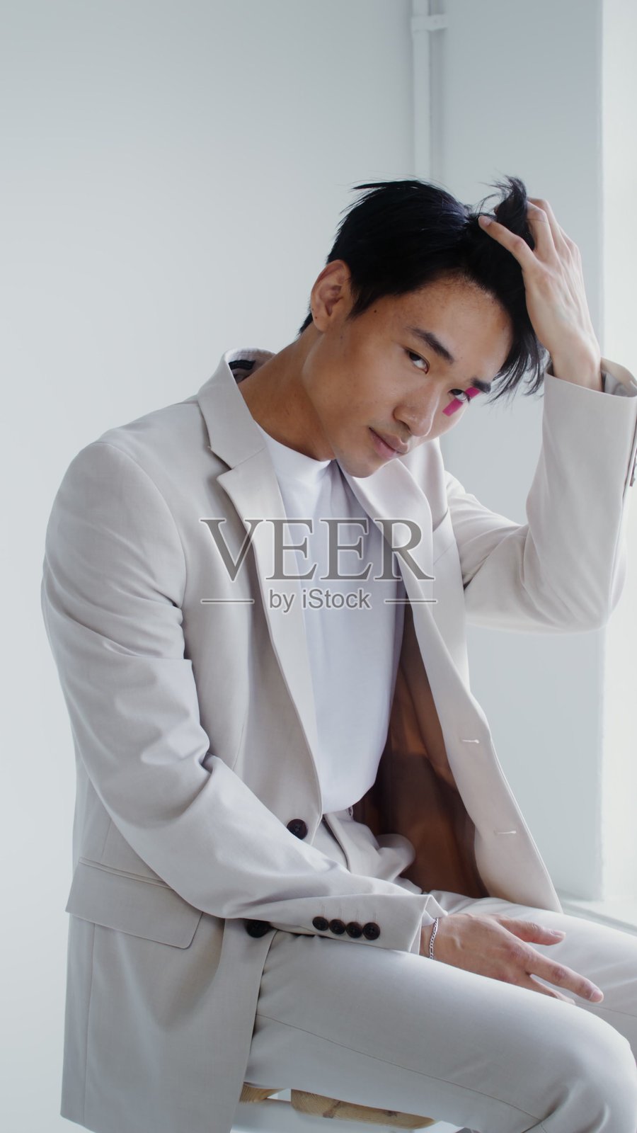 一个男人脸上沾着粉色油漆。照片摄影图片