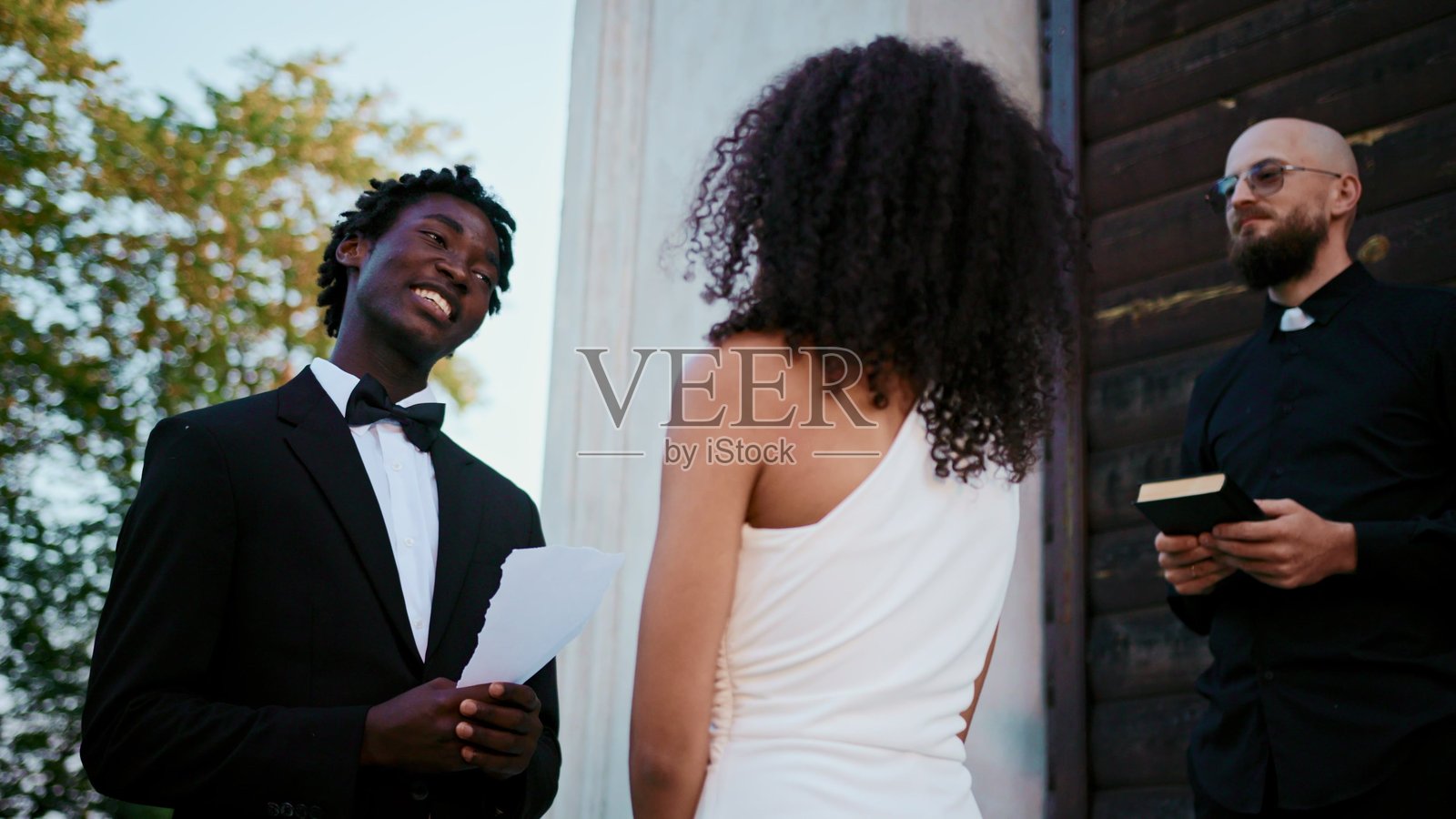 新郎在阅读婚礼誓词，目光专注。照片摄影图片