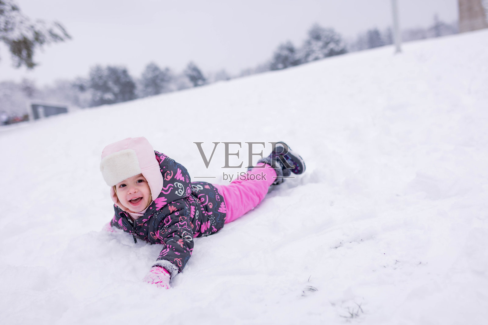 穿着冬装的快乐孩子在雪地里玩耍照片摄影图片