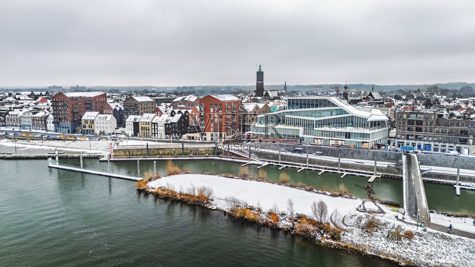荷兰林堡省冬季雪景，从空中无人机视角拍摄的马斯河畔的芬洛镇，展现了屋顶被白雪覆盖的冬季城市风光。照片摄影图片