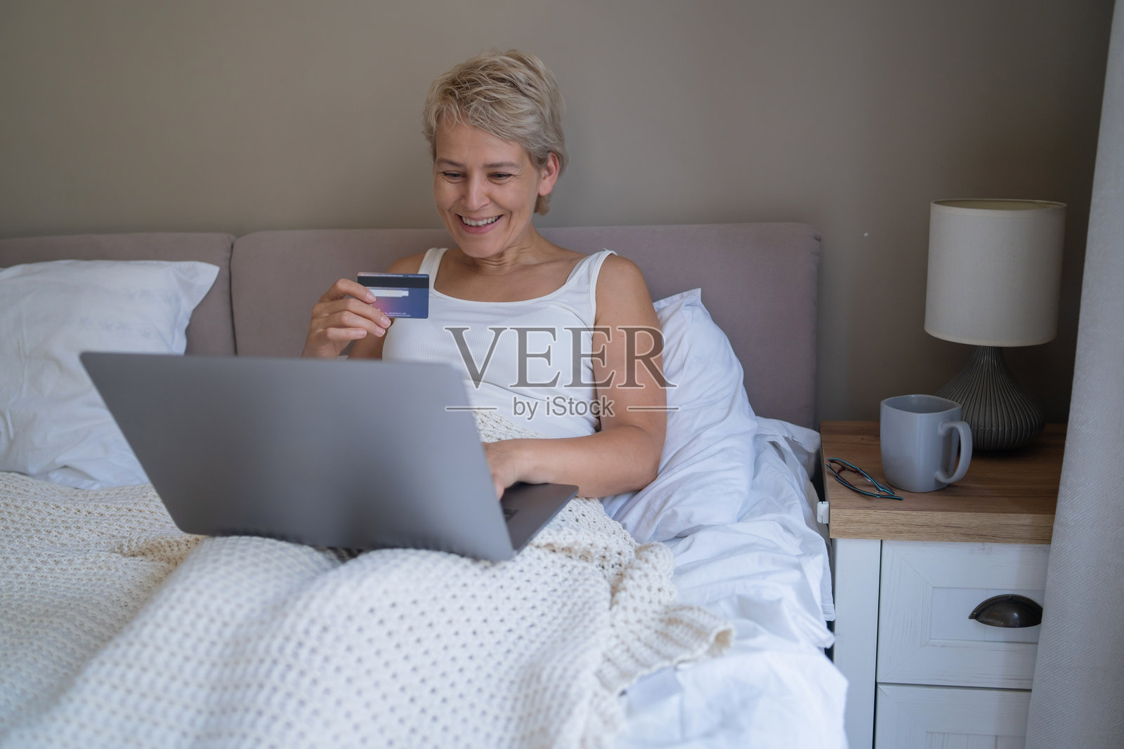 床上充满喜悦的网购时刻照片摄影图片