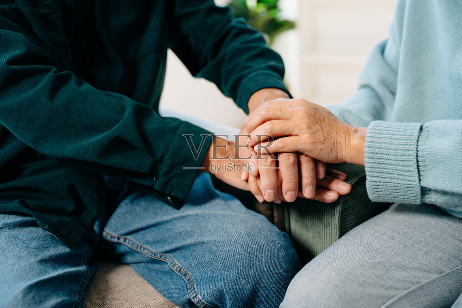 老人的手和女人的手放在桌子上照片摄影图片