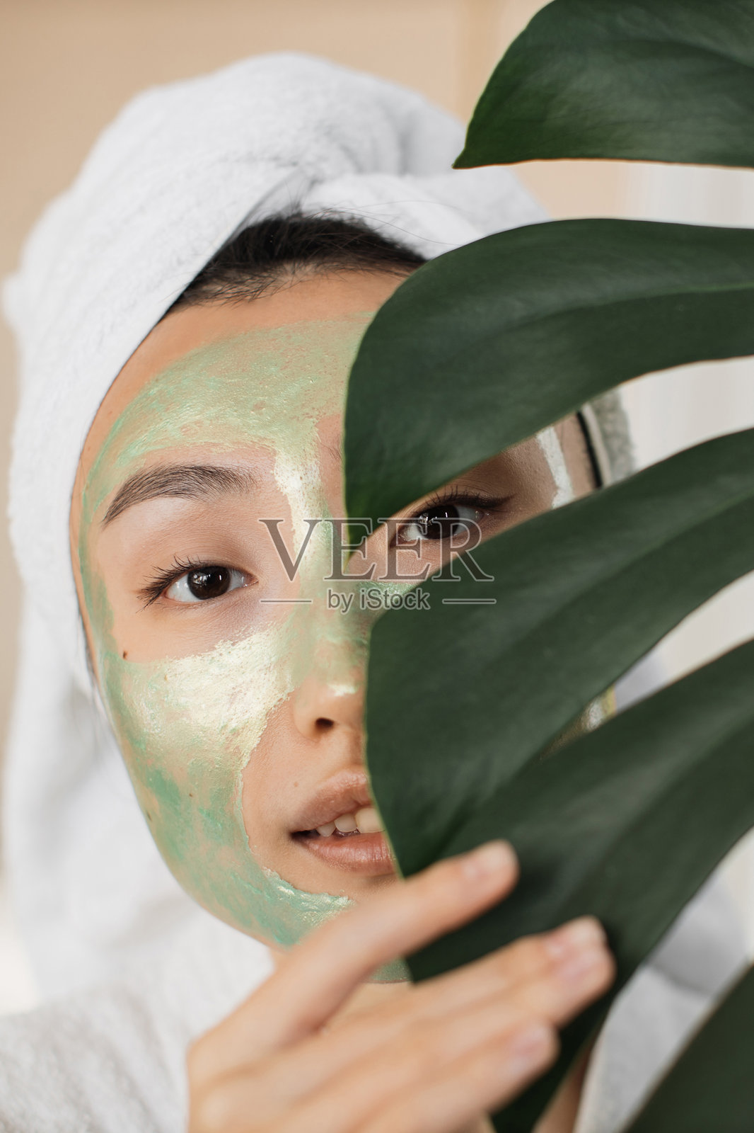 敷着绿色面膜的女性照片摄影图片