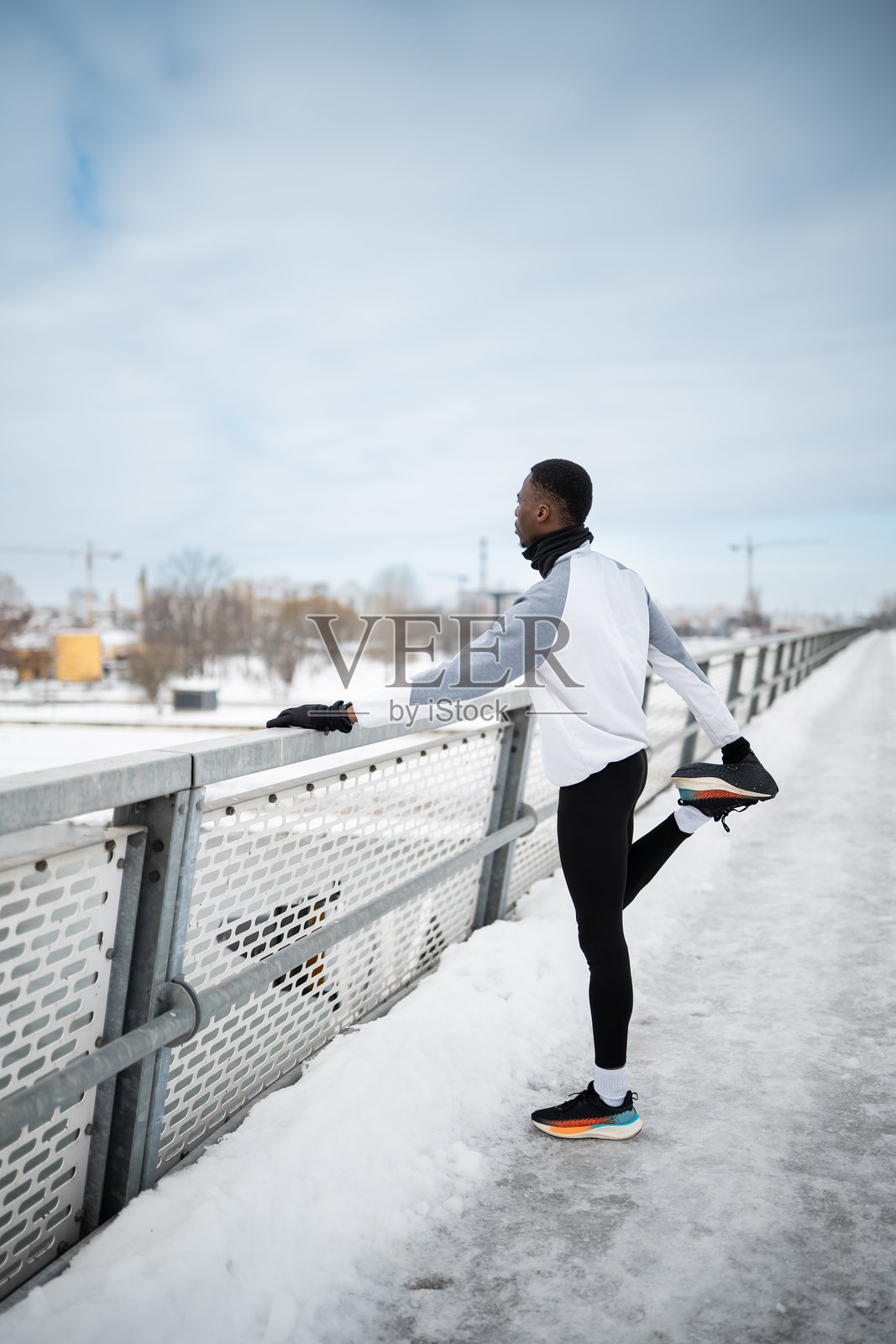 运动员在户外进行冬季跑步前的热身照片摄影图片
