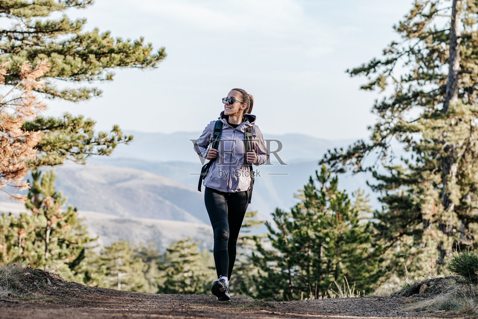 日出时，背包客徒步登山的活跃女性照片摄影图片